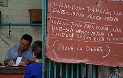 Cuba has two parallel currencies: National Pesos and Convertibles to Dollars (CUCs). National pesos only buy goods in bulk, limited with a "Libreta" to a fixed quantity each month. This sign specifies the amount of chicken: 1 pound per person). Havana (La Habana), Cuba