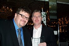 Deery with Michael Moore in 2005 after accepting NBR award John Deery NBR photo.jpg