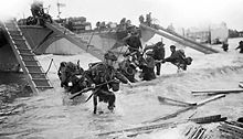 Headquarters personnel of 4th Special Service Brigade, making their way from LCI(S)s (Landing Craft Infantry Small) onto 'Nan Red' Beach, JUNO Area, at St Aubin-sur-Mer at about 9 am on 6 June 1944 Landings at St Aubin-sur-Mer.jpg