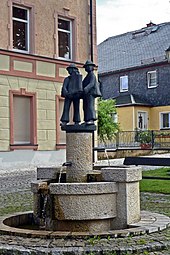 Zierbrunnen in Harra mit den Harcher Leingstamausern