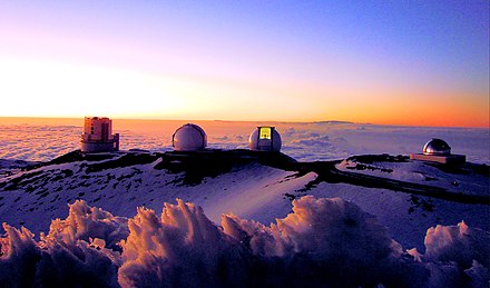Sunset over four telescopes of the Mauna Kea Observatories. From left to right: the Subaru Telescope, the twin Keck I and II telescopes, and the NASA Infrared Telescope Facility.