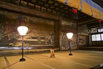 Tatami mattat rum med en storskalig väggmålning av en domstolsplats.