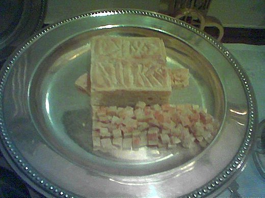 The particles placed on the diskos during the Divine Liturgy. The large cube is the Lamb, the triangle to the left is the particle for the Theotokos taken out of the Panagia.