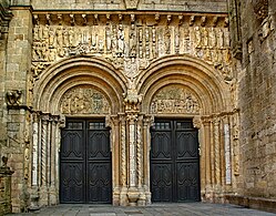 A Porta de Praterías, Catedral de Santiago de Compostela, do Mestre Esteban, tem duas grandes aberturas com tímpanos apoiados em colchetes.  O friso esculpido acima é protegido por beiral sobre mísulas.