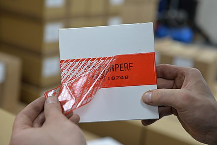 A tamper evident label with a perforated tape that permanently displays a visual 'VOID OPENED' message after being opened. Security tamper evident label showing a void message when removed.jpg