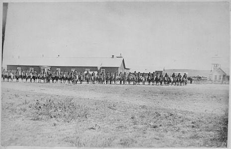 
Sioux Indian police lined up on horseback in front of Pine Ridge Agency buildings, Dakota Territory
