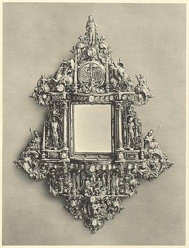 Spiegelrahmen in dem architektonischen Aufbau eines Wandepitaphs mit reichem getriebenen Figurenschmuck und Schweifwerk-Ornament sowie mit hintermalten Glasmedaillons besetzt. Die Figuren verkörpern den Traum des Propheten Daniel von dem ewigen Reich. Arbeit des Warburger Meisters Anton Eisenhoit, vollendet 1592