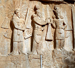 Investiture of King Ardashir II by the angelic divinity Mithra (left) and Shapur II (right); the dead body of Julian is trampled underfoot. Reliefs at Taq-e Bostan. Taq-e Bostan - High-relief of Ardeshir II investiture.jpg