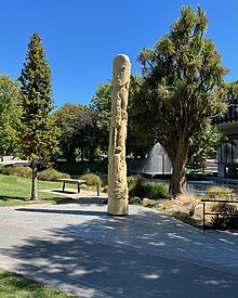 The pouwhenua Te Ahi Kaa stands in front of the Town Hall, on the south bank of the Avon River. Te Ahi Kaa Pouwhenua, Victoria Square.jpg