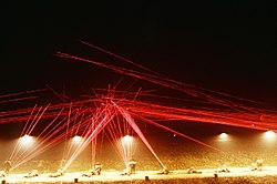 Tracer fire lights up the night sky as Marine recruits engage targets during a live-fire exercise..