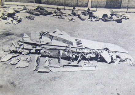 A large piece of the damaged DC-7 tailfin laying flat with the "United" logo partially visible.