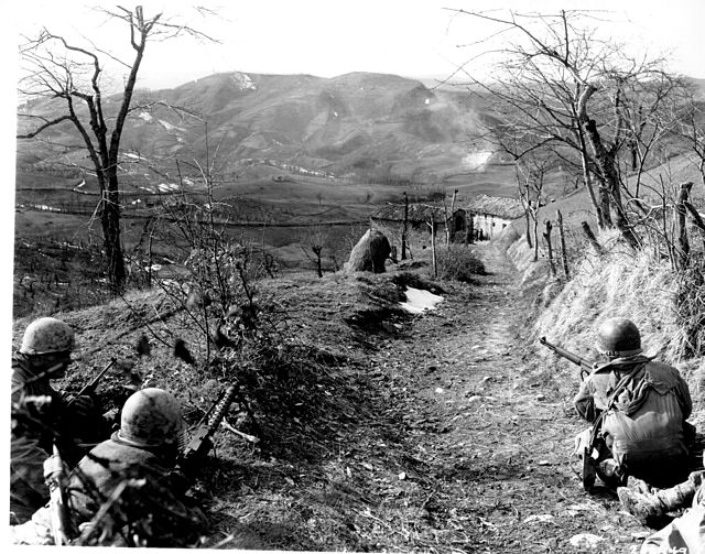 A machine gunner and two riflemen of Company "K" of the 87th Mountain Infantry Regiment, 10th Mountain Division, cover an assault squad routing German