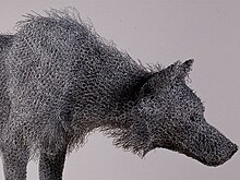 Foto dettagliata della testa di un lupo di legno realizzata da Kendra Haste in cui si possono vedere i dettagli dei singoli fili.