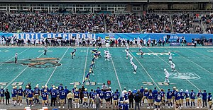 The teams at the line of scrimmage in the second quarter, with Tulsa (blue) on offense and Old Dominion (white) on defense 2021 Myrtle Beach Bowl scrimmage.jpg