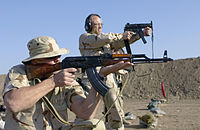 Foreground: A member of the United States Air Force field-qualifying with a USSR AKM in Iraq