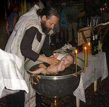 [2] ein orthodoxer Priester bei der Taufe