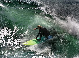 Un surfeur à Santa Cruz en Californie. La côte du nord de la Californie est réputée pour ses spots de surf, mais la température de l'eau est toujours basse (14 ºC) et nécessite le port d'une combinaison. (définition réelle 2 289 × 1 700)