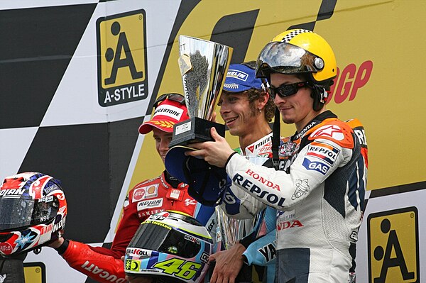 Casey Stoner, Valentino Rossi and Nicky Hayden, celebrating on the podium after finishing second, first and third at the MotoGP race.