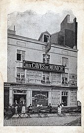 Carte postale en noir et blanc. Photo d'une façade et terrasse d'un taverne.
