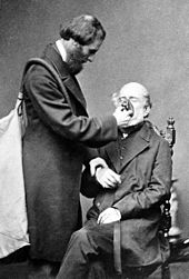 Joseph Thomas Clover demonstrating the Chloroform apparatus he invented in 1862 Clover with his chloroform apparatus 1862.jpg