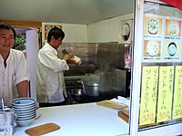 Peeling thin strips of dough from a loaf directly into a container of boiling water to make daoxiaomian (刀削面)