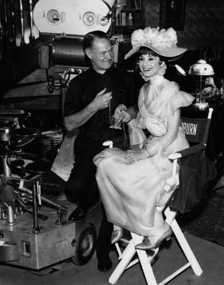 Cinematographer Harry Stradling poses with Audrey Hepburn as Eliza Doolittle on the set of the film