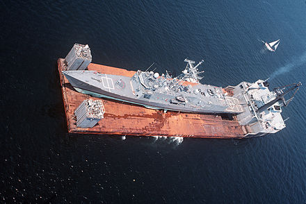 L'objet du casus-belli, la frégate USS Samuel B. Roberts en cours de rapatriement à bord du navire semi-submersible Mighty Servant 2 après avoir touché une mine iranienne.