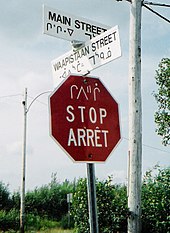 Signalisation routière trilingue en cri, anglais et français à Mistissini.