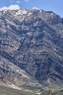Rock strata towering 1,600 m (5,200 ft) above Mud
