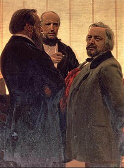 Tri muškarca stoje zajedno - dva muškarca sa bradama, onaj sa desne strane sa sedom kosom, uz trećeg čoveka koji ih pažljivo posmatra