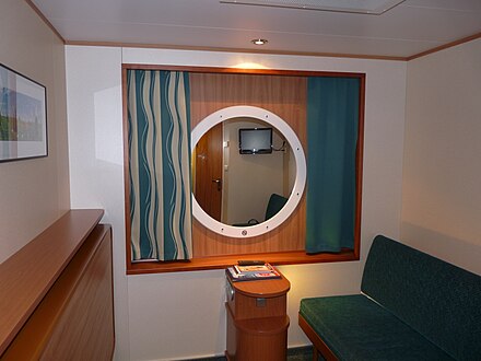 Two-person interior cabin with beds packed away in the day. Note the "window". The standard cabins have bunk beds.