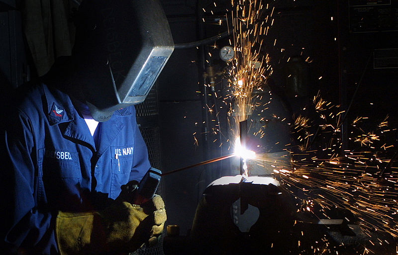 File:US Navy 021028-N-7222M-002 A sailor welds a steel piece of iron which will be used to make repairs to the ship's hull.jpg