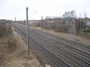 An electrified railway line with housing beyond