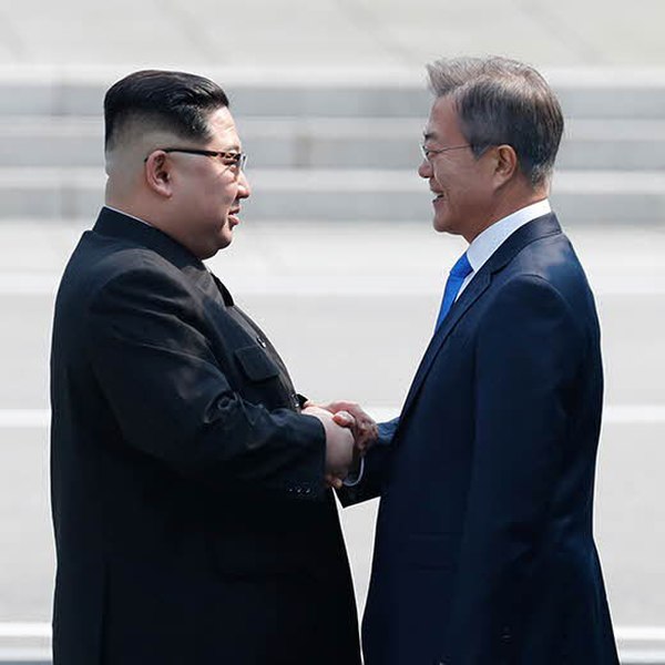 Kim and Moon shake hands in greeting at the demarcation line.