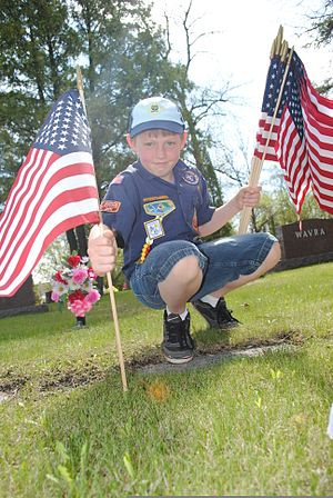 A Cub Scout, with Troop 319, places an American flag on the gravesite of a U.S. Soldier who served in the Spanish-American War at Calvary Cemetery in Grand Forks, N.D., May 24, 2013 130524-F-JB669-040.jpg