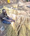A_man_weaving_grass_to_be_used_for_roofing_thatch_rooms_in_Northern_Ghana