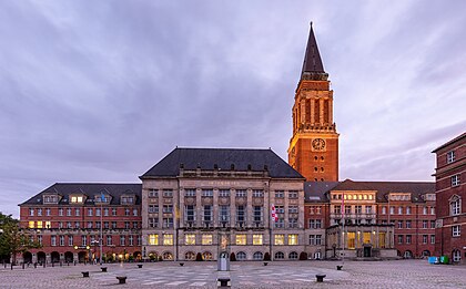 Prefeitura de Kiel, capital de Schleswig-Holstein, Alemanha. Sua torre, de 105 m de altura, é um dos marcos da cidade. Ela pode ser visitada como parte das visitas guiadas. Um elevador sobe até o nível de observação a uma altura de 67 m, que circunda a torre e oferece amplas vistas sobre o centro da cidade e o porto no nordeste, a margem oriental do Fiorde de Kiel, a estação ferroviária principal, o extremo sul do fiorde, chamado de Hörn e os distritos ocidentais, como o Mettenhof, o mais populoso de Kiel. (definição 6 527 × 4 053)