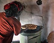 Žena peče chleba na elektrické plotně