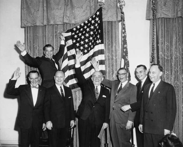 Bartlett, (bottom, third from right), celebrating Alaska Statehood next to a 49-star U.S. Flag, held by Robert Atwood.