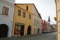 Čeština: Město Domažlice. Domy čp. 83 (žlutý vlevo) a 84 (hnědý vpravo) v Hradské ulici. Zcela vlevo část modrého domu čp. 82, dále vpravo další domy v Hradské ulici, v pozadí věž Chodského hradu.