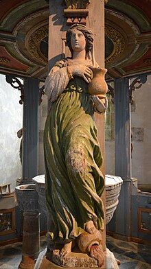 Representation of temperance (painted wood sculpture, dated 1683, which covers the shrine of the baptismal church Breton Commana in France). Temperance's foot tips over a jug of wine, and presents a pitcher of water Eglise de Commana2012 469.JPG