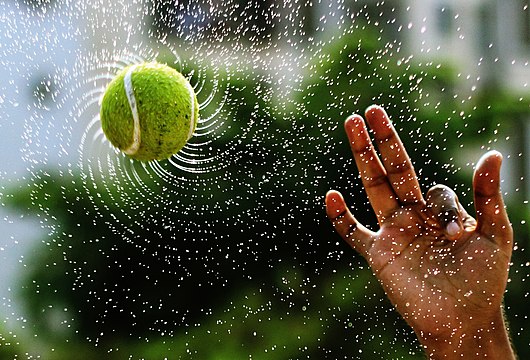 Water droplets fly off a wet, spinning ball in equiangular spirals