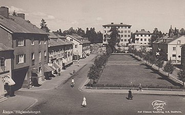 Höglandstorget, vy mot Höglandsskolan, 1935. Höglandsbiografen var ännu inte byggd. Planteringen omringas av staket och nyplanterade träd.