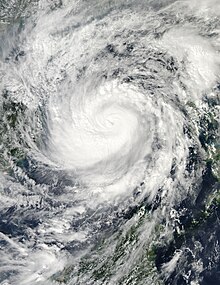 Image of a tropical cyclone between landmasses. Though the storm does not exhibit an eye, it has a large central mass of clouds and rainbands.