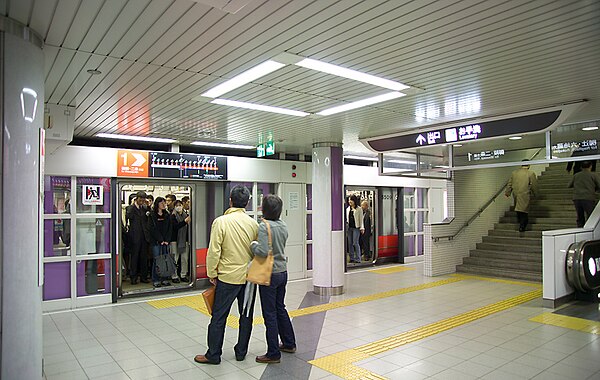 Passengers await the departure of a train at Yamashina Station