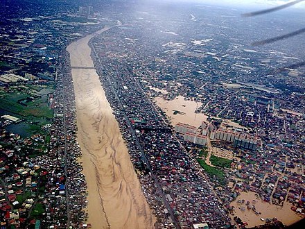 An aerial view of the Manggahan floodway with shanty towns on either side. During the 2009 flooding of Typhoon Ketsana, the illegal settlements reduced the floodway's effectiveness.[9]