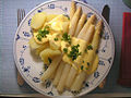 Boiled white asparagus served with potatoes and sauce hollandaise