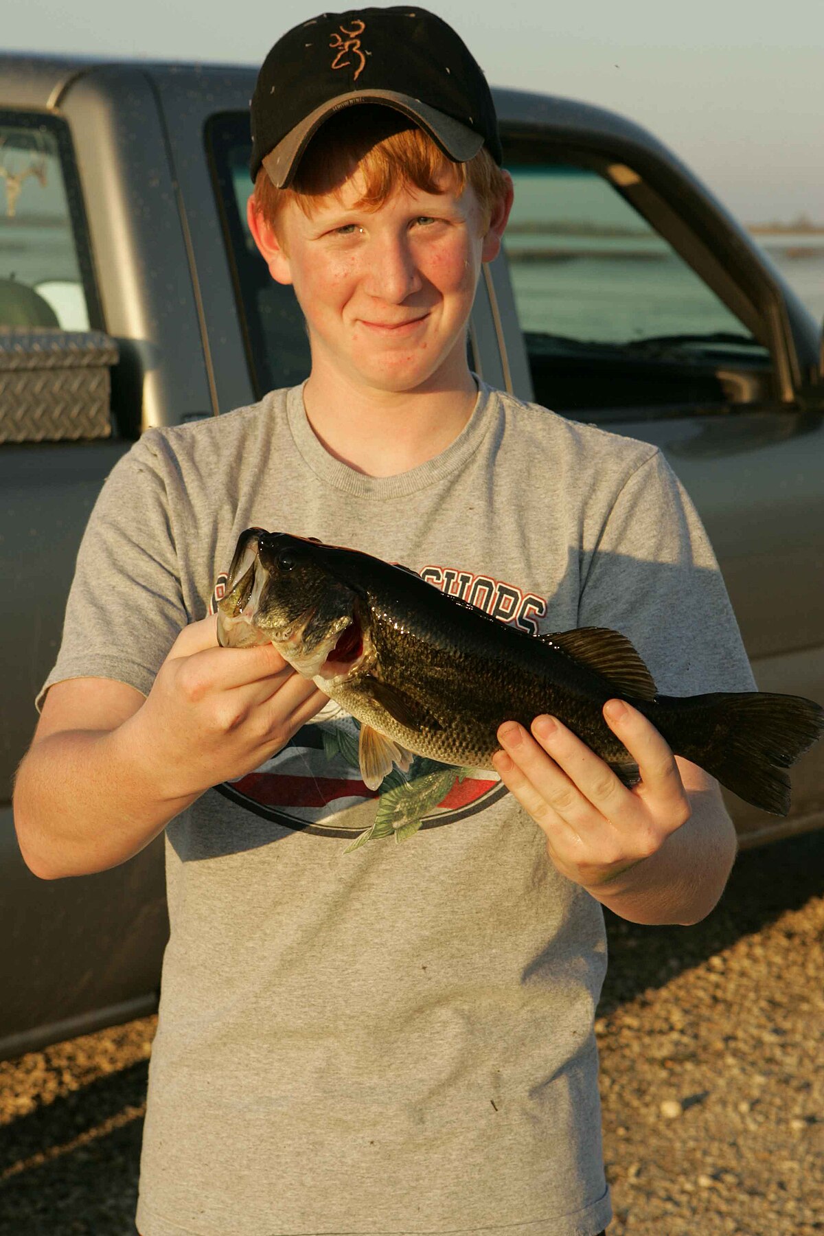 File:Teenage redhead boy proudly holding fresh caught bass.jpg