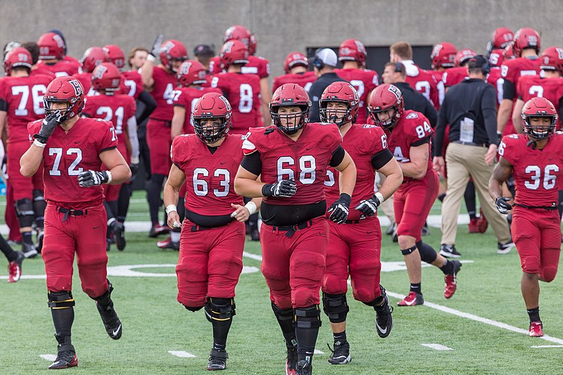 The Harvard football team takes the field.