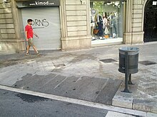 Trash can mounted to curb ramp (18445603951).jpg